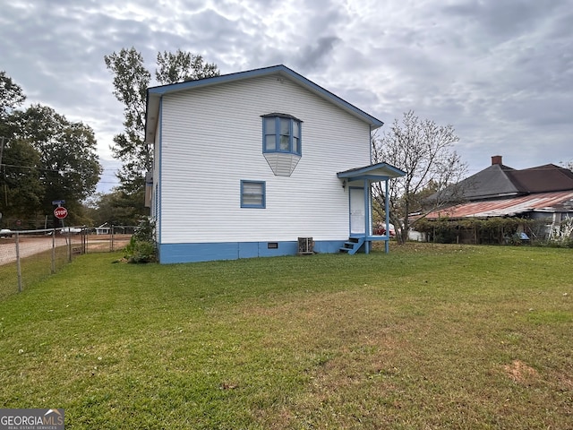 back of house featuring a lawn and central AC