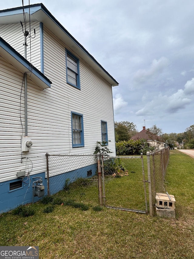 view of side of home with a yard