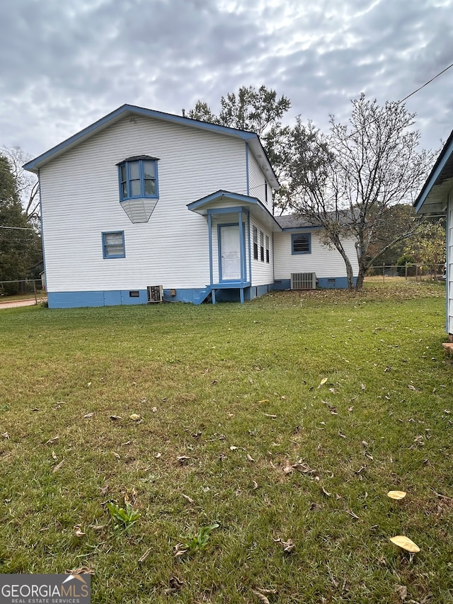 view of property exterior with cooling unit and a yard