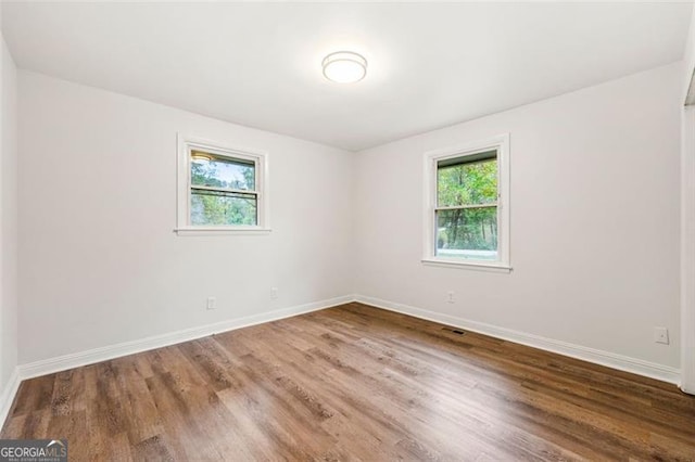 spare room featuring hardwood / wood-style floors and a healthy amount of sunlight