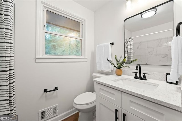 bathroom featuring vanity, toilet, and walk in shower