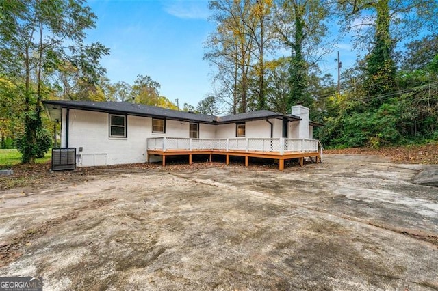 rear view of house featuring central AC and a deck