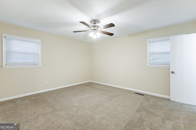 unfurnished room featuring a textured ceiling, light carpet, and ceiling fan