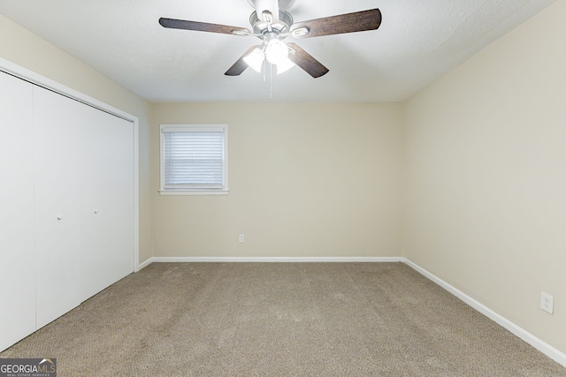 unfurnished bedroom with carpet, ceiling fan, and a closet