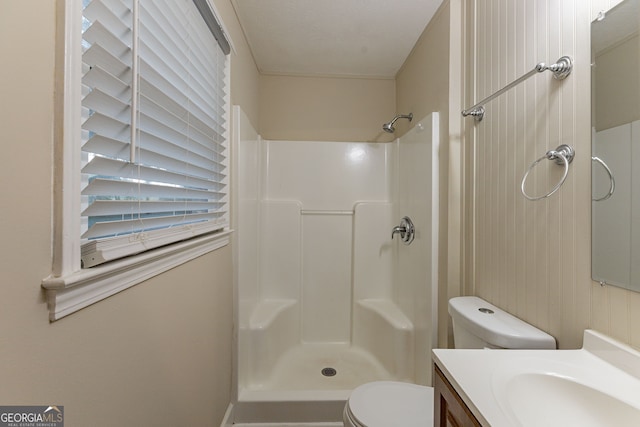 bathroom featuring walk in shower, vanity, and toilet