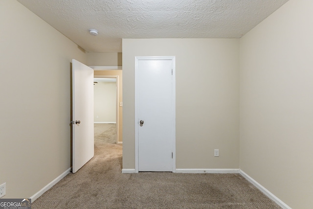 unfurnished bedroom featuring a textured ceiling and carpet floors