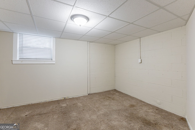 empty room featuring a paneled ceiling and carpet