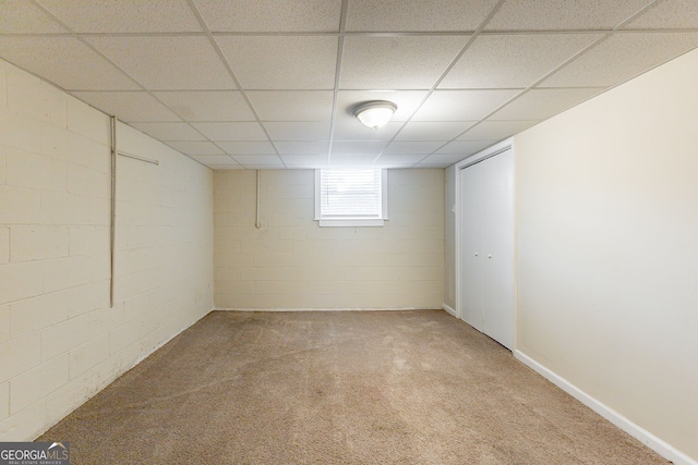 basement featuring carpet floors and a drop ceiling