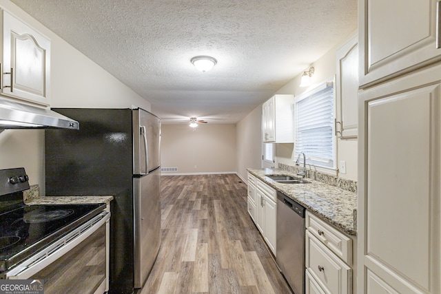 3730 Douglas Ridge Trl, Douglasville, GA 30135 - kitchen featuring appliances with stainless steel finishes, a sink, a ceiling fan, light wood-style floors, and white cabinetry