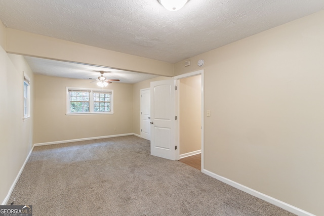 empty room featuring carpet, a textured ceiling, and ceiling fan
