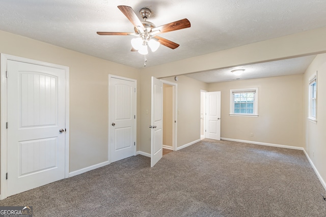 unfurnished bedroom featuring a textured ceiling, ceiling fan, and carpet floors