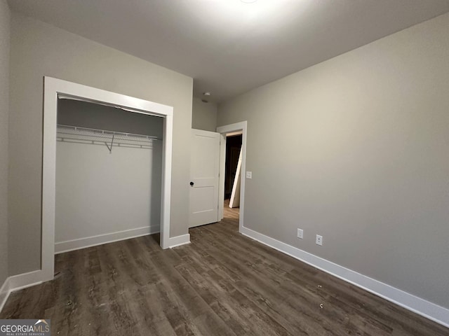 unfurnished bedroom featuring a closet and dark hardwood / wood-style floors