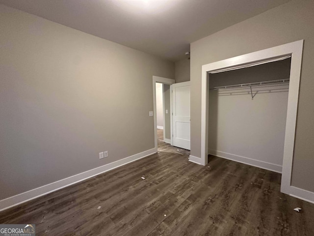 unfurnished bedroom featuring a closet and dark wood-type flooring