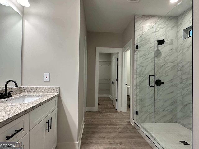 bathroom with a shower with door, vanity, and hardwood / wood-style flooring