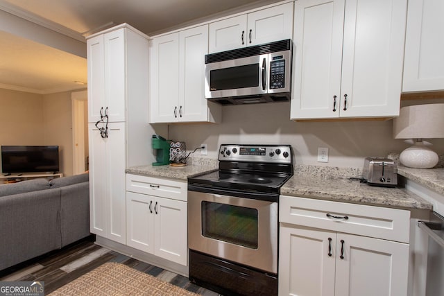 kitchen with stainless steel appliances, ornamental molding, and white cabinets