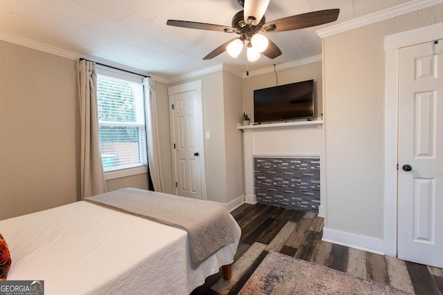 bedroom featuring baseboards, a textured wall, wood finished floors, and crown molding