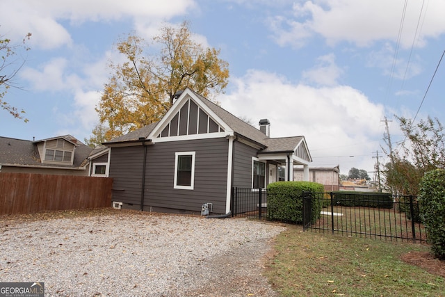 rear view of property with a chimney, fence, and roof with shingles