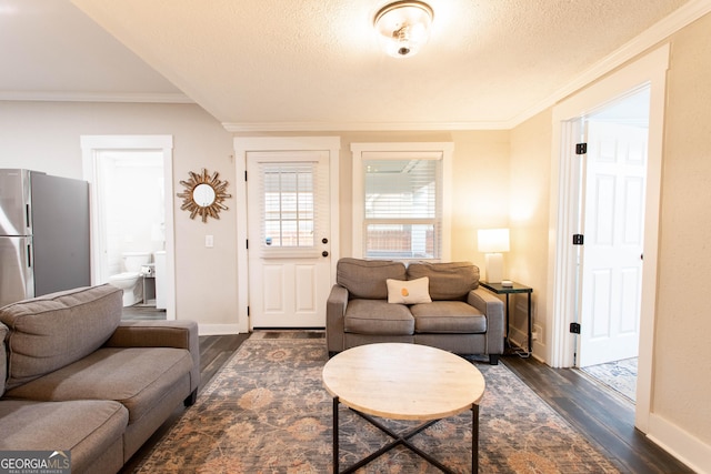 living area with crown molding, dark wood finished floors, a textured ceiling, and baseboards