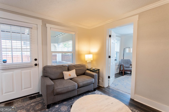 living room featuring a healthy amount of sunlight, a textured ceiling, dark wood-type flooring, and crown molding