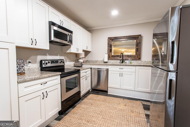 kitchen featuring stainless steel appliances, ornamental molding, white cabinetry, a sink, and light stone countertops