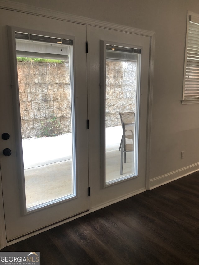 doorway with dark wood-type flooring and plenty of natural light