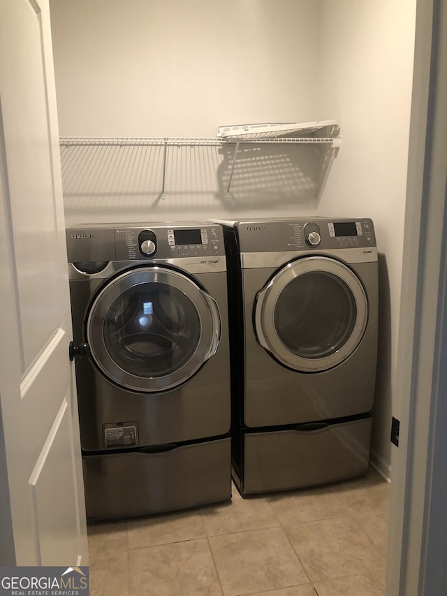 laundry room featuring light tile patterned flooring and separate washer and dryer