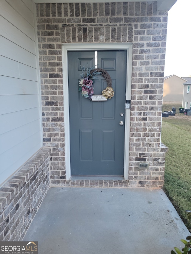 doorway to property featuring a lawn