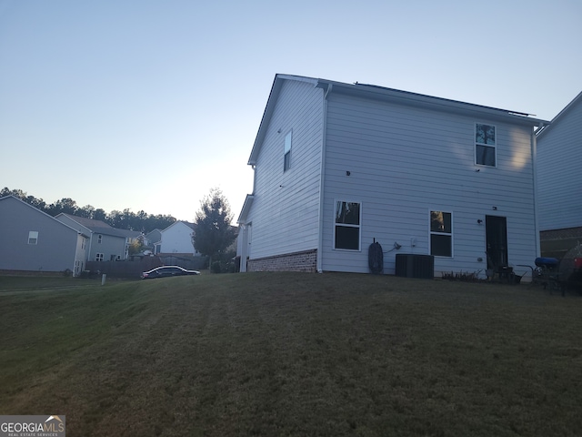 exterior space with cooling unit and a lawn