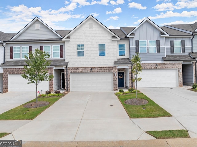 multi unit property with brick siding, board and batten siding, an attached garage, and driveway