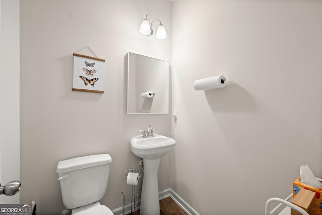 bathroom with toilet and baseboards