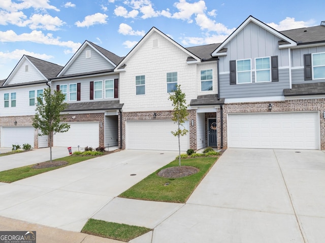 townhome / multi-family property with a garage, concrete driveway, brick siding, and board and batten siding