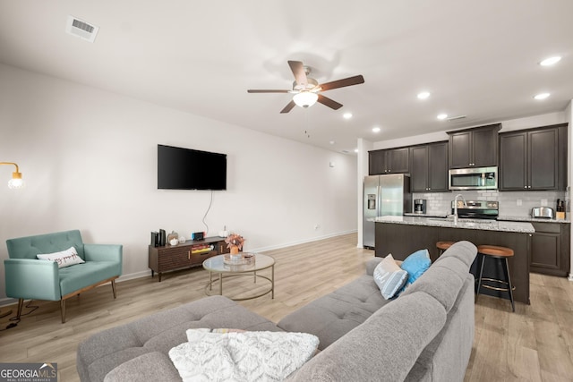 living area with recessed lighting, a ceiling fan, visible vents, and light wood finished floors