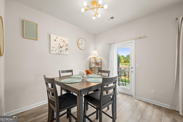 dining area featuring visible vents, baseboards, a notable chandelier, and light wood-style flooring