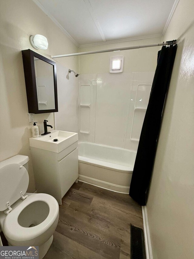 full bathroom with crown molding, wood-type flooring, toilet, and shower / bath combo with shower curtain