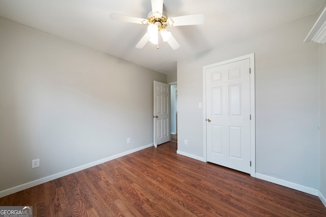 unfurnished bedroom featuring dark wood-type flooring and ceiling fan