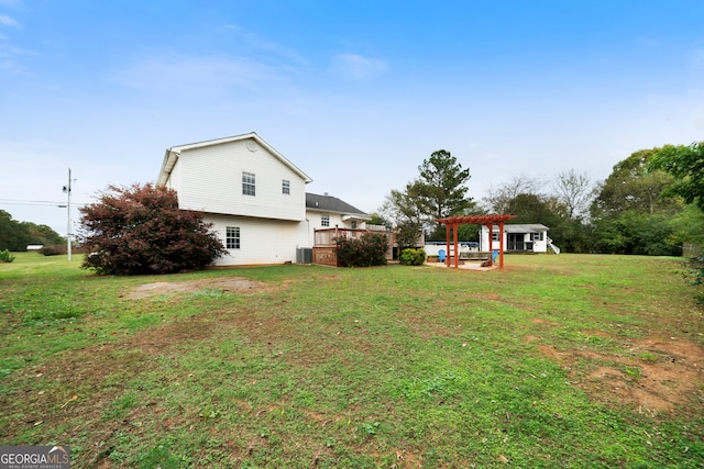 view of yard featuring a wooden deck, a pergola, and central AC