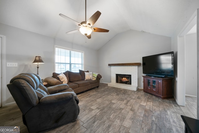 living room featuring lofted ceiling, wood-type flooring, ceiling fan, and a brick fireplace