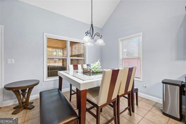 tiled dining area featuring high vaulted ceiling and a chandelier