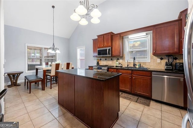 kitchen with sink, a notable chandelier, appliances with stainless steel finishes, hanging light fixtures, and a center island