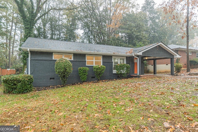 ranch-style house with a carport and a front lawn