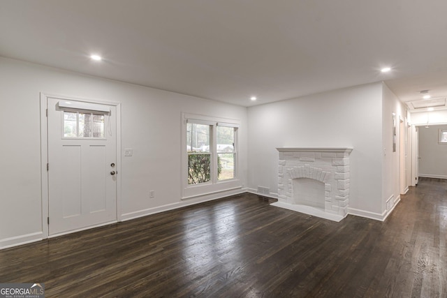 unfurnished living room featuring a fireplace and dark hardwood / wood-style floors