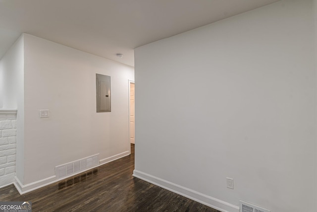 empty room featuring dark hardwood / wood-style floors and electric panel