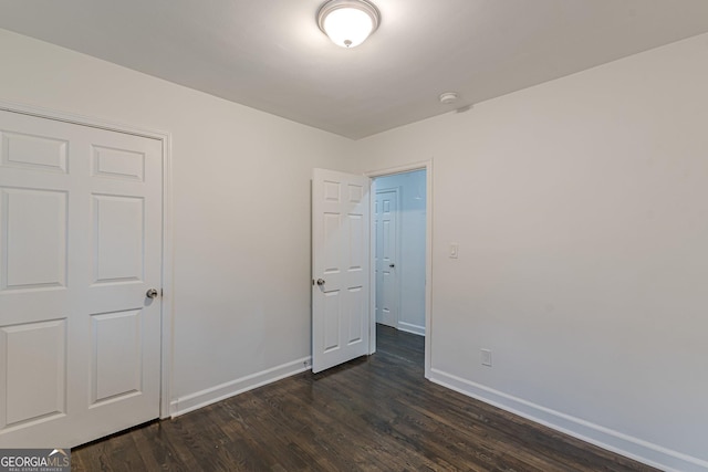 unfurnished bedroom featuring dark wood-type flooring and a closet