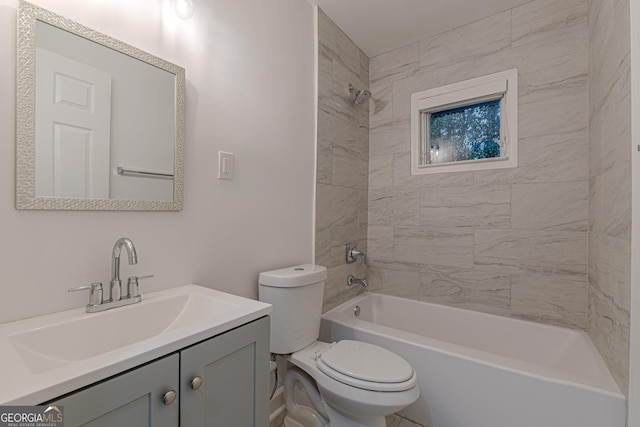 full bathroom featuring tiled shower / bath, vanity, and toilet