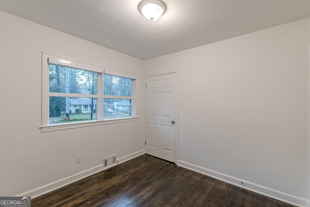 spare room featuring dark wood-type flooring