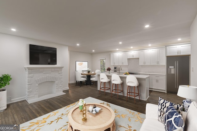 living room with dark hardwood / wood-style flooring, sink, and a brick fireplace