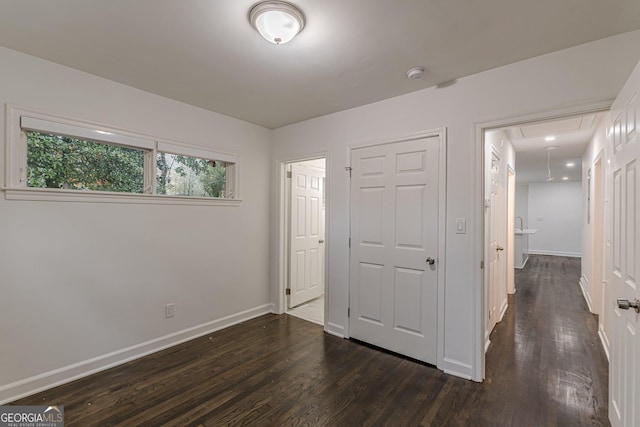 unfurnished bedroom with a closet and dark wood-type flooring