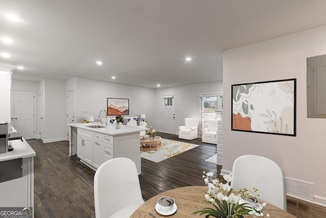 dining area featuring dark hardwood / wood-style flooring, sink, and electric panel