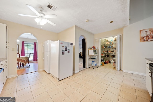 kitchen with white cabinetry, white fridge, light tile patterned floors, and ceiling fan