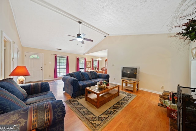 living room with vaulted ceiling with beams, ceiling fan, light wood-type flooring, and a textured ceiling